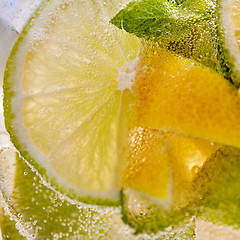 Image showing Macro background of lemonade with pieces of lemon and bubbles of air.