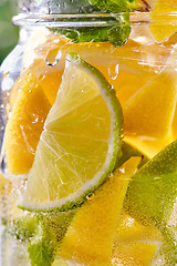 Image showing Cold refreshing water with lime and lemon in a glass.