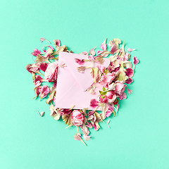 Image showing Roses flowers heart with envelope for post card on a light turquoise background.