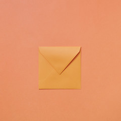 Image showing Empty handmade mock up envelope on a peach color background .