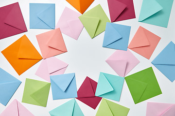 Image showing Colorful frame from empty handmade envelopes on a light background.