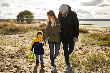 Image showing happy family walking along autumn beach