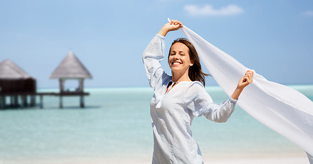 Image showing happy woman with shawl waving in wind on beach