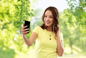 Image showing smiling teenage girl taking selfie by smartphone