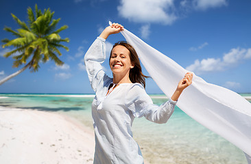 Image showing happy woman with shawl waving in wind on beach
