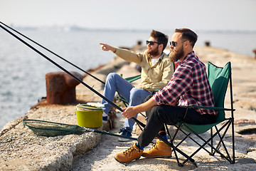 Image showing happy friends with fishing rods on pier