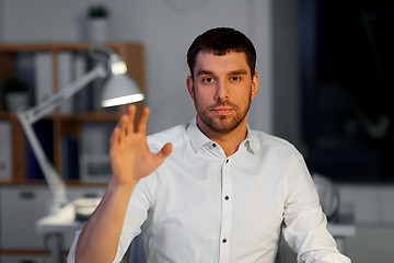 Image showing businessman using gestures at night office