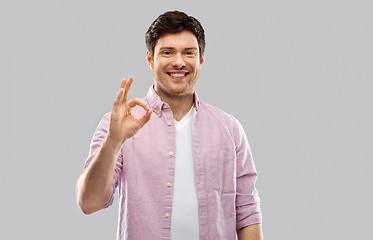 Image showing smiling young man showing ok hand sign