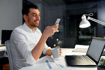 Image showing businessman with smartphone and coffee at office