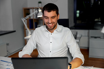 Image showing businessman with laptop working at night office