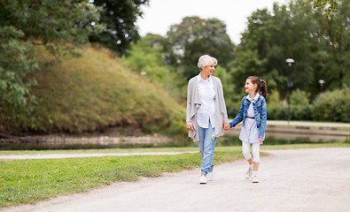 Image showing grandmother and granddaughter walking at park