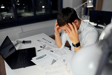 Image showing businessman with papers working at night office