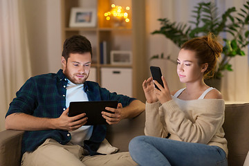 Image showing couple with tablet computer and smartphone at home