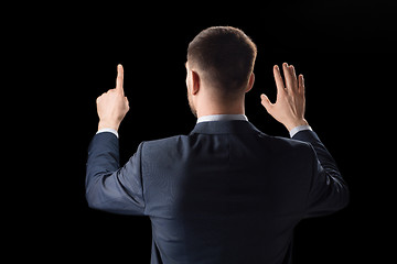 Image showing businessman working with invisible virtual screen