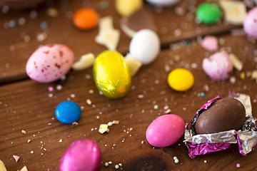 Image showing chocolate eggs and candy drops on wooden table