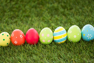 Image showing row of colored easter eggs on artificial grass