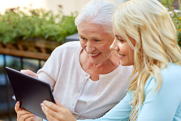 Image showing daughter with tablet pc and senior mother outdoors