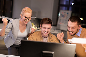 Image showing business team celebrating success at night office