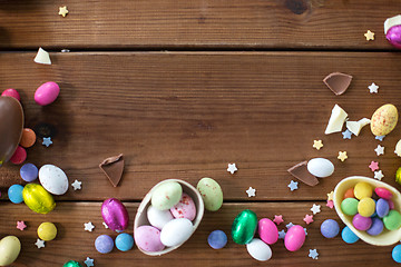 Image showing chocolate eggs and candy drops on wooden table