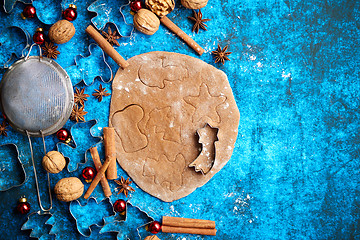 Image showing Christmas baking concept. Gingerbread dough with different cutter shapes