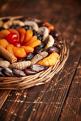 Image showing Mix of dried fruits in a small wicker basket on wooden table