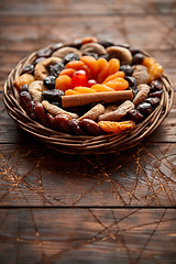 Image showing Mix of dried fruits in a small wicker basket on wooden table