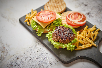 Image showing Two tasty grilled home made burgers with beef, tomato, onion and lettuce