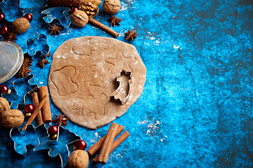 Image showing Christmas baking concept. Gingerbread dough with different cutter shapes