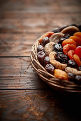 Image showing Mix of dried fruits in a small wicker basket on wooden table