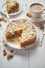 Image showing Whole delicious apple cake with almonds served on wooden table