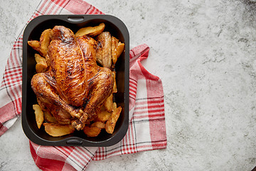 Image showing Roasted chicken or turkey with potatoes in black steel mold