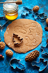 Image showing Christmas baking concept. Gingerbread dough with different cutter shapes