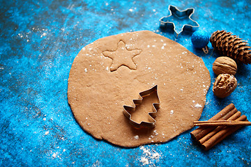 Image showing Christmas baking concept. Gingerbread dough with different cutter shapes