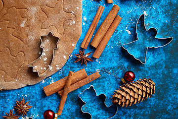 Image showing Christmas baking concept. Gingerbread dough with different cutter shapes