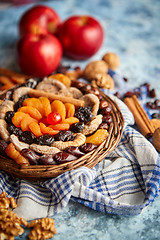 Image showing Composition of dried fruits and nuts in small wicker bowl placed on stone table