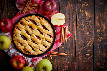 Image showing Homemade pastry apple pie with bakery products on dark wooden kitchen table