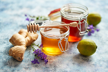 Image showing Healthy food table with different kinds of honey, fresh ginger and lime