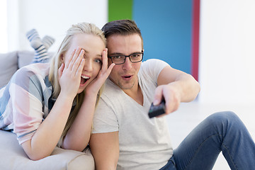 Image showing Young couple on the sofa watching television