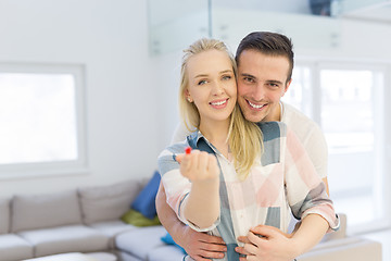 Image showing couple showing small red house in hands