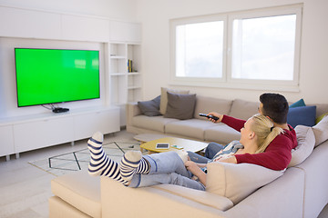 Image showing Young couple on the sofa watching television