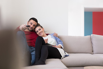 Image showing Young couple on the sofa watching television