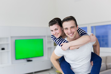 Image showing handsome man piggybacking his girlfriend