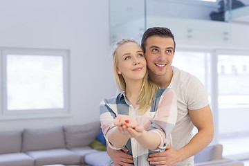 Image showing couple showing small red house in hands