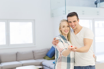 Image showing couple showing small red house in hands