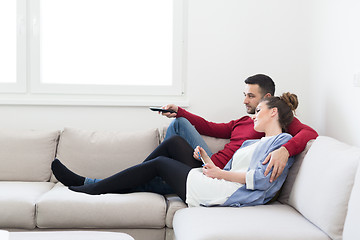 Image showing Young couple on the sofa watching television