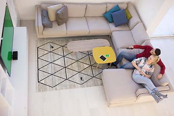 Image showing Young couple on the sofa watching television