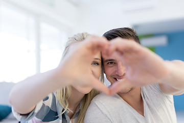 Image showing couple making heart with hands