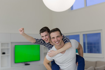 Image showing handsome man piggybacking his girlfriend