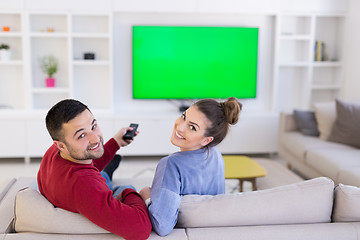 Image showing Young couple on the sofa watching television