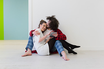 Image showing Young Couple using digital tablet on the floor